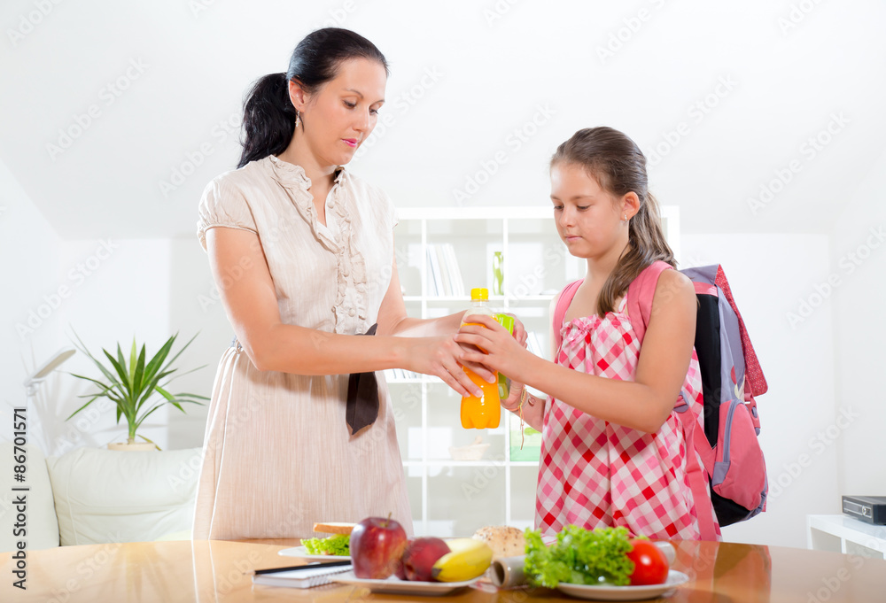 Mother making breakfast for her children in the morning and a snack for school