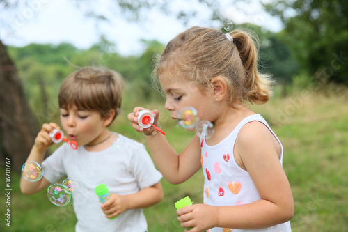 Kids in garden blowing soap bubbles