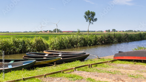 Typical Dutch landscape with wooden rowing boats and modern wind