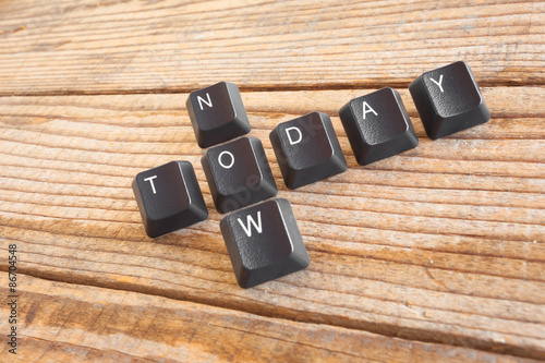 "TODAY NOW" wrote with keyboard keys on wooden background