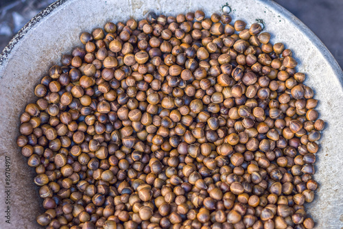 Roasted seeds of Lithocarpus fruit in metal pan for sale