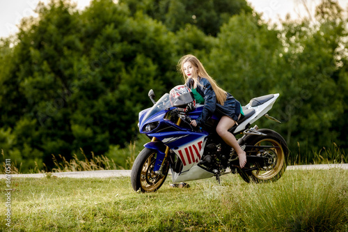 beautiful young woman with a motorcycle speed in nature © czamfir