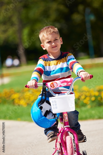 happy boy learning to ride his first bike
