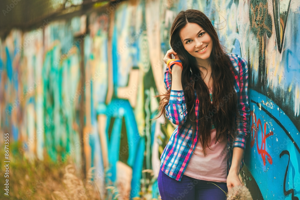 Naklejka premium The girl against a wall with graffiti.