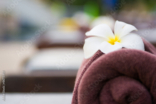 brown roll towel with plumeria on beach chair