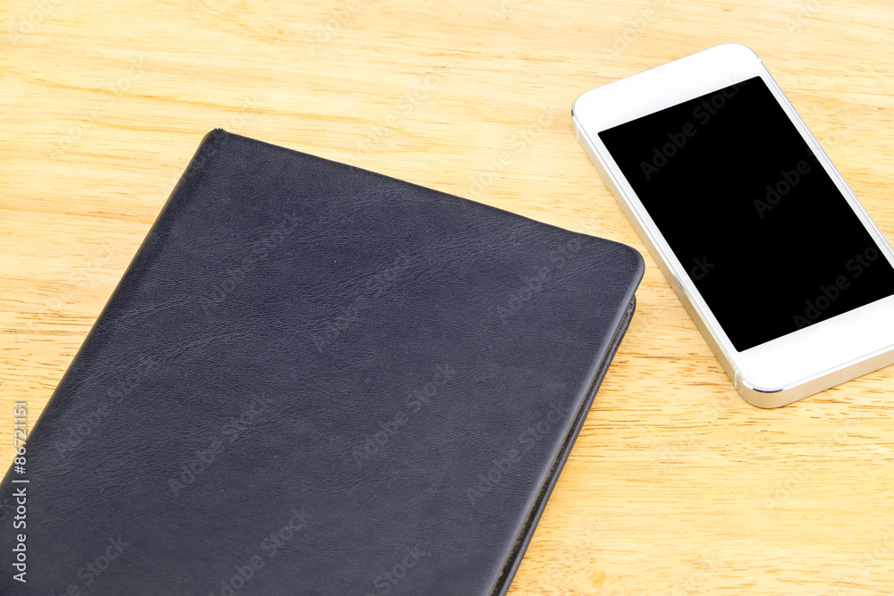Close black blank notebook and mobile on wooden table,Mock up fo Close black blank notebook and mobile on wooden table,Mock up fo