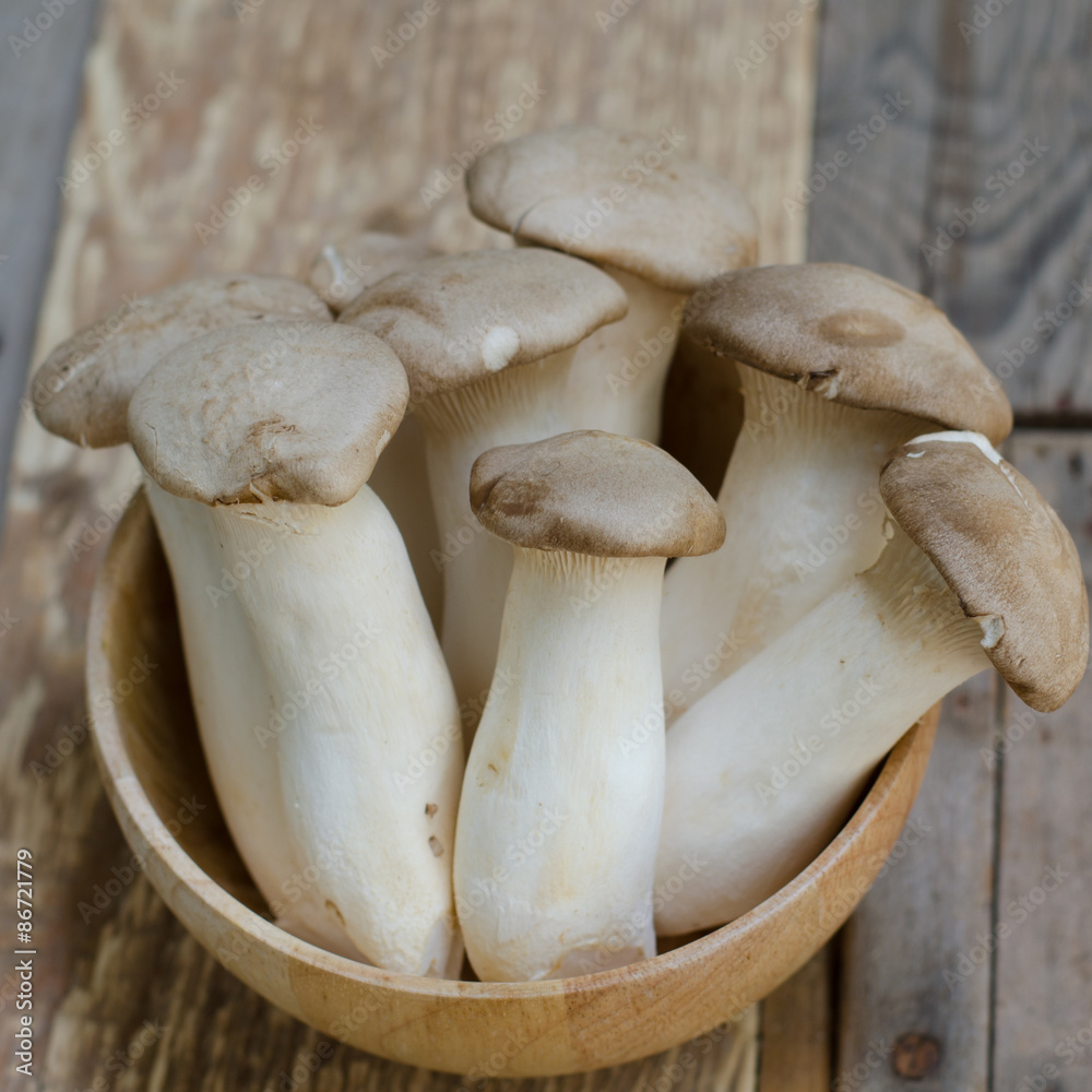 King oyster mushroom Pleurotus eryngii in wooden bowl King oyster mushroom Pleurotus eryngii in wooden bowl