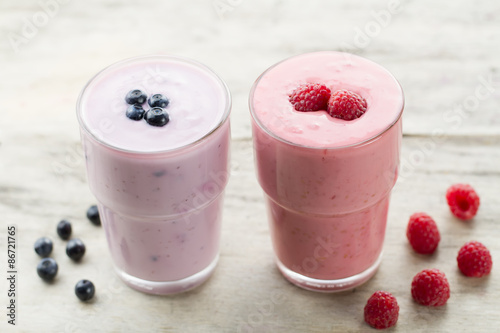 Raspberry and blueberry smoothie with berries on wooden background. Healthy vegetarian food, diet.