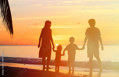happy family with two kids on sunset beach