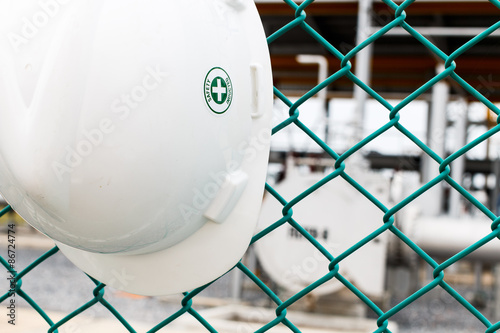 Helmet hang on green net fence