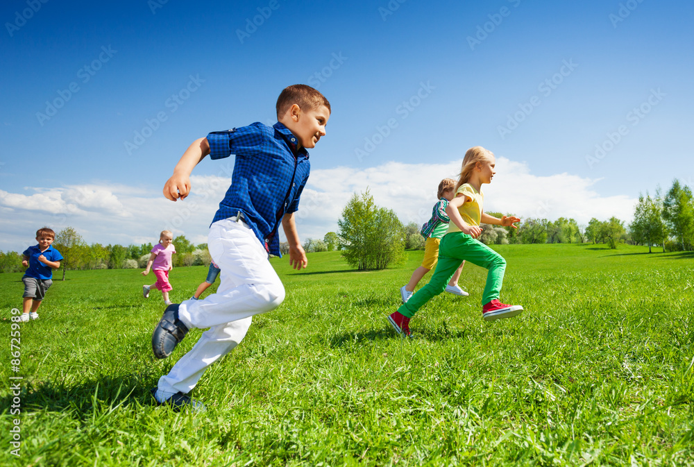 Happy running kids in the green park during day Happy running kids in the green park during day