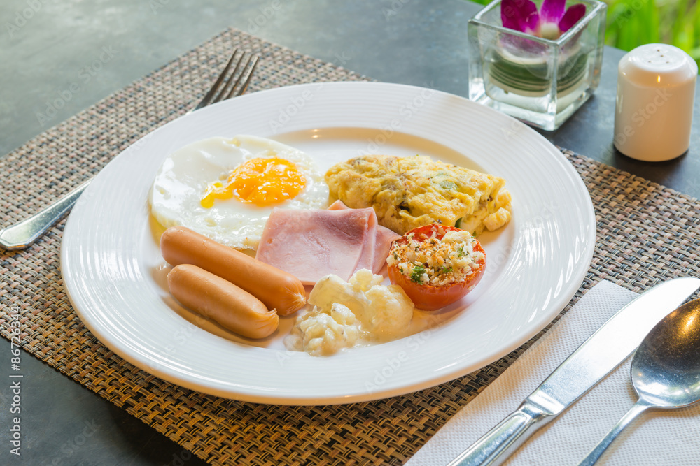 Plate with fried eggs, bacon and chicken sausage