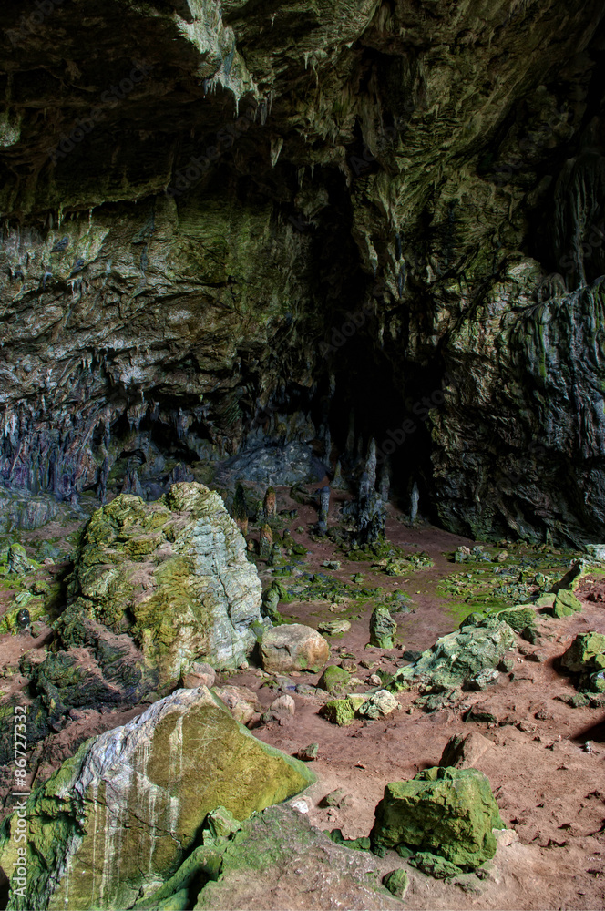 Nimara cave with moss covered rocks and red soil Nimara cave with moss covered rocks and red soil