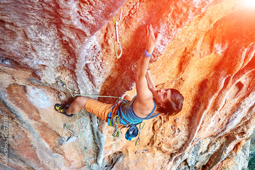 Canvas Print Rock climber climbing up a cliff