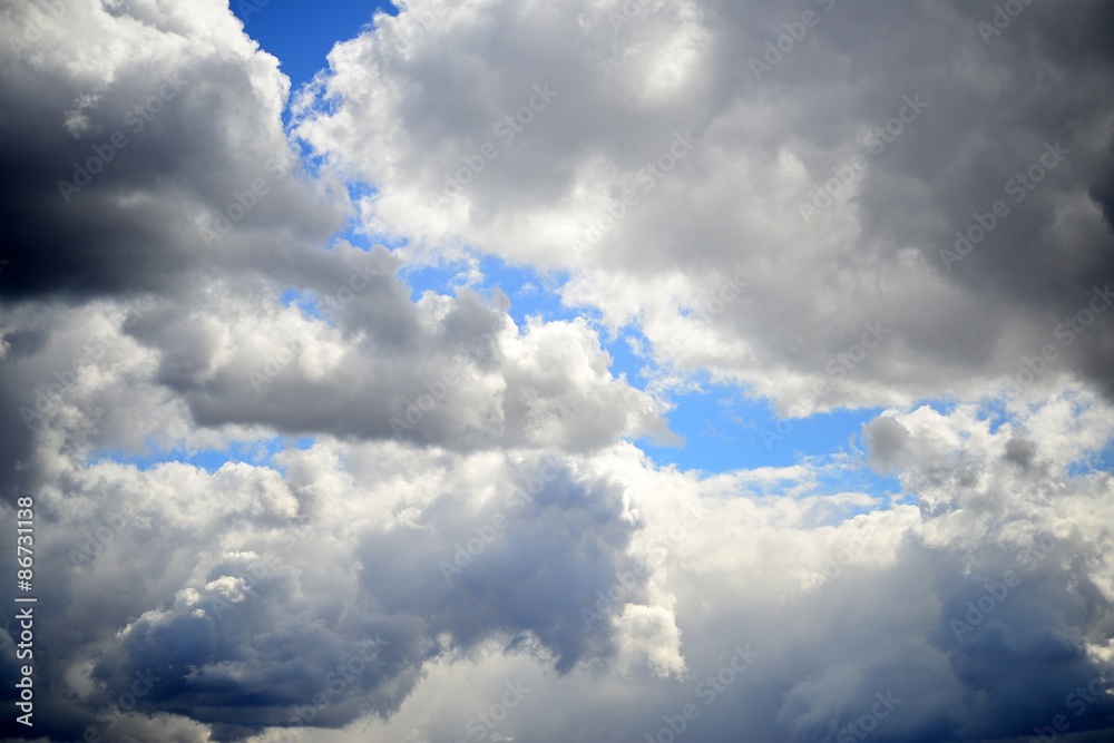 Naklejka premium Big fluffy white and dark clouds in the blue sky