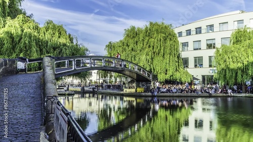 Time lapse view of people crossing a bridge over the canal at Camden town at the entrance of the famous Lock market in London photo