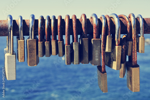 rusty padlocks on a railing near the sea