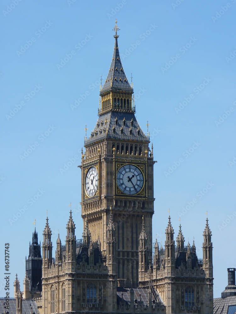 The iconic Big Ben clock tower rising over the Houses of Parliament by the banks of the River Thames in London, England.
