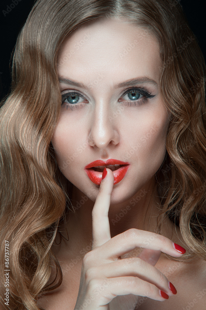 Portrait of beautiful young women with red lips, wavy hair, black eyeliner. Beauty. Studio shot. Black background. Portrait of beautiful young women with red lips, wavy hair, black eyeliner. Beauty. Studio shot. Black background.