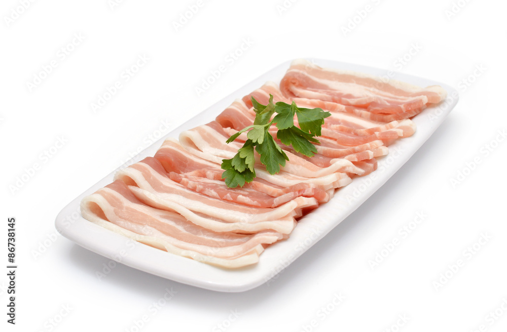 Slices of bacon with parsley on the plate isolated on white Slices of bacon with parsley on the plate isolated on white