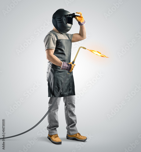 worker welder in a protective mask with gas welding machine photo