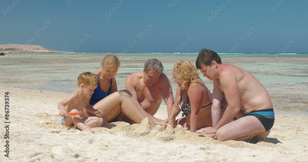 Big family building sand castle together Big family building sand castle together