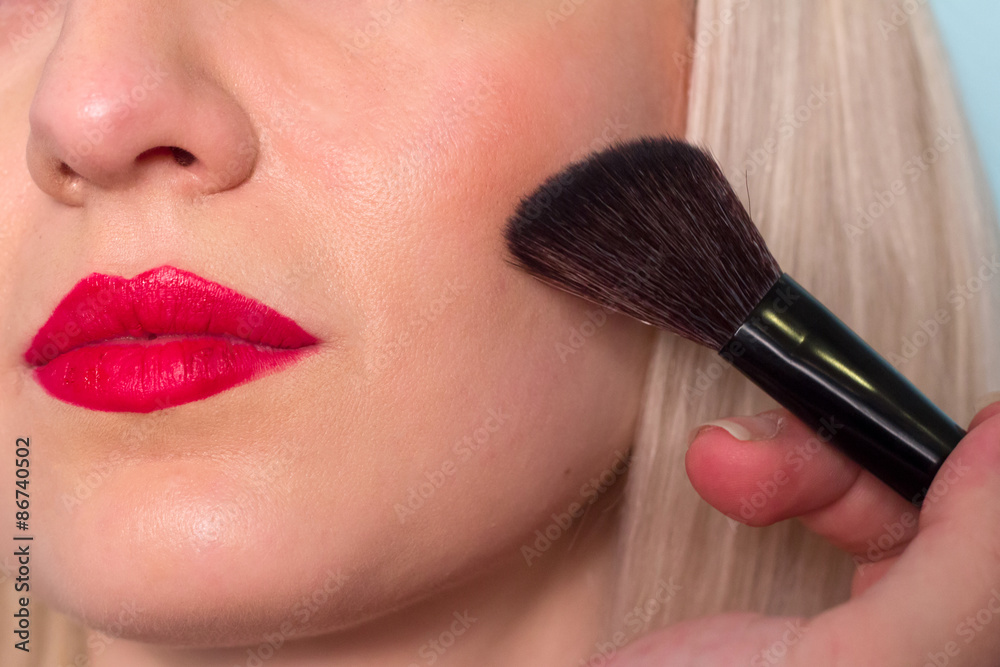 Makeup artist paints a woman blush cheekbones. Makeup.