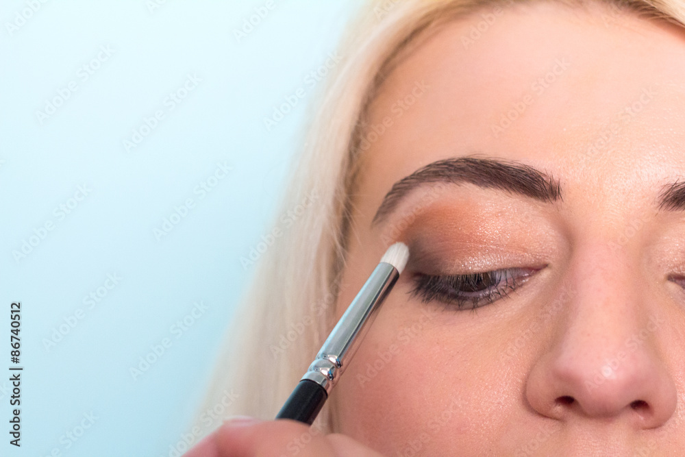 Makeup artist paints a eyes of woman. Makeup.