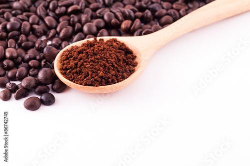 Coffee beans and ground coffee on wooden spoon isolated on white