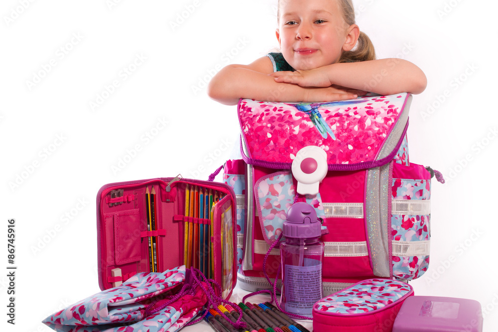 Stockfoto med beskrivningen lächelnd präsentiert ein Kind zur Einschulung die neuen Schulsachen