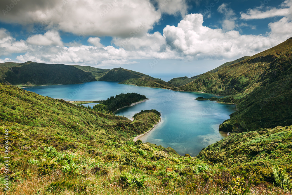 Panoramic view of Lagoa do Fogo, a crater lake within the Agua de Pau Massif stratovolcano in the center of the island of Sao Miguel in the Portuguese archipelago of the Azores. Panoramic view of Lagoa do Fogo, a crater lake within the Agua de Pau Massif stratovolcano in the center of the island of Sao Miguel in the Portuguese archipelago of the Azores.
