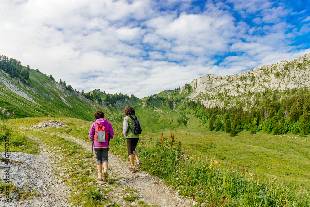 Two hikers women walking in the mountains
