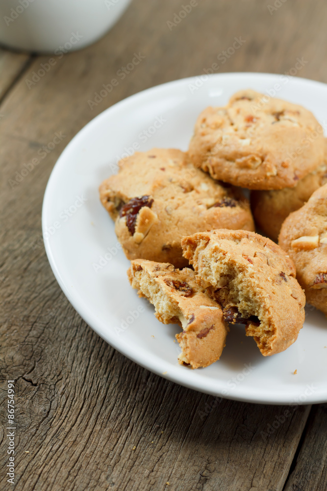 Chocolate chip cookies on white disk on wooden table Chocolate chip cookies on white disk on wooden table