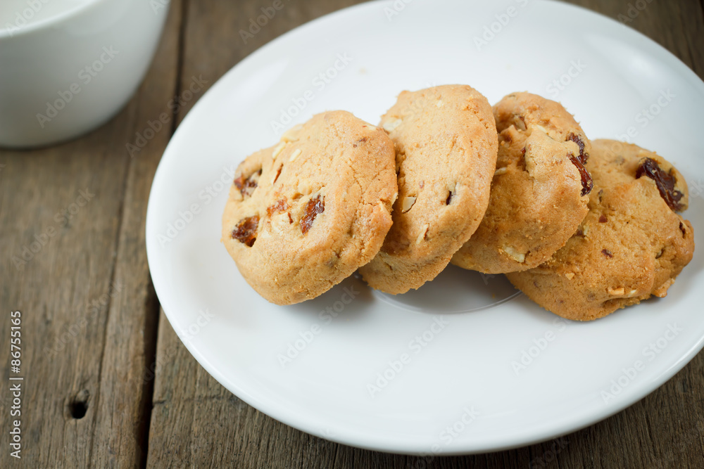 Chocolate chip cookies on white disk on wooden table Chocolate chip cookies on white disk on wooden table
