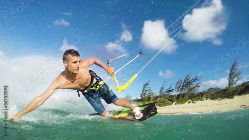 Young Man Kite Boarding in Ocean. Extreme Summer Sport in Slow Motion.