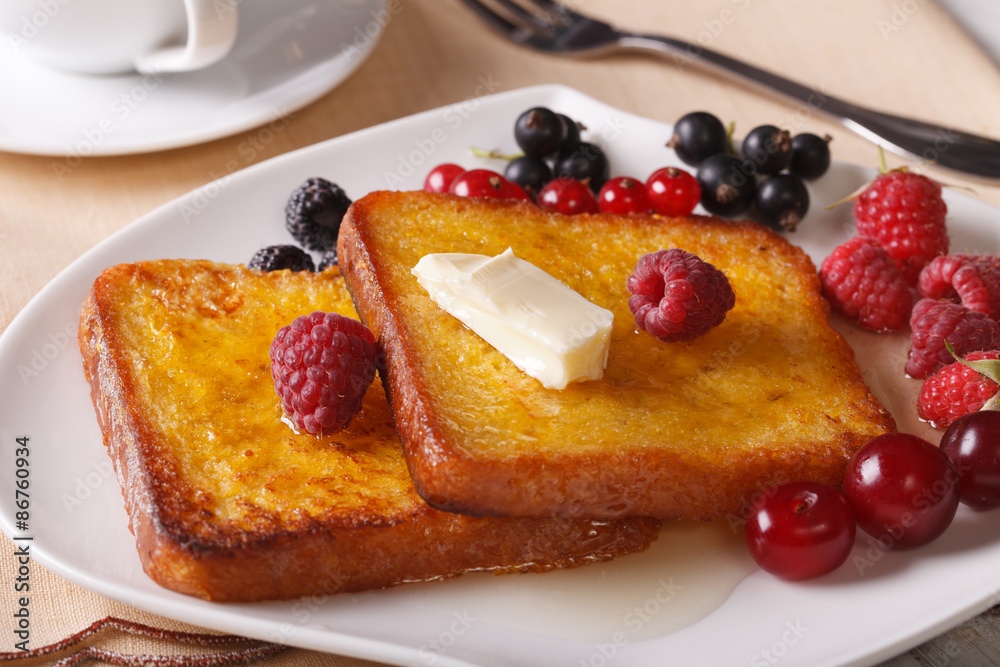 Two French toast with honey and berries close-up. Horizontal
Two French toast with honey and berries close-up. Horizontal