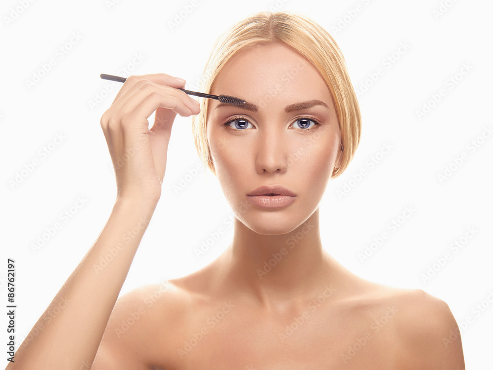 young blonde woman applying make-up