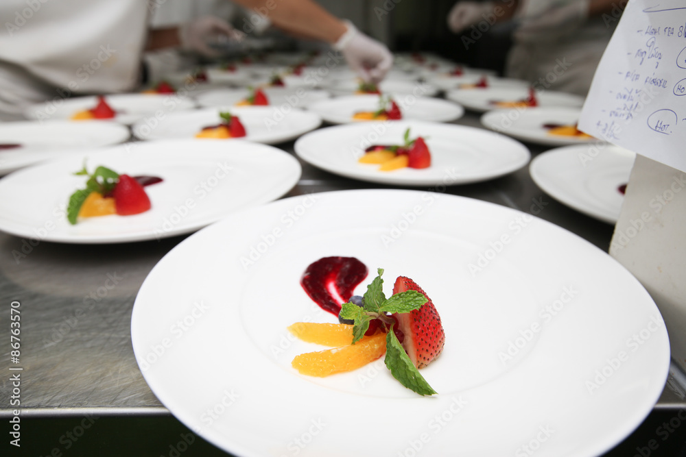 Chef in hotel or restaurant kitchen cooking for dinner Chef in hotel or restaurant kitchen cooking for dinner
