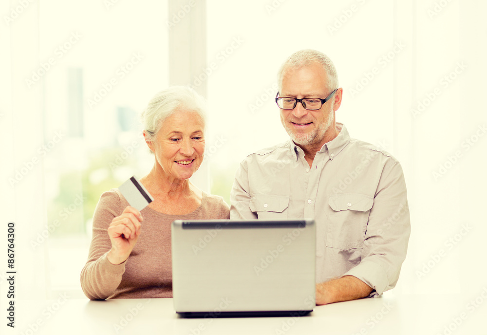 happy senior couple with laptop and credit card