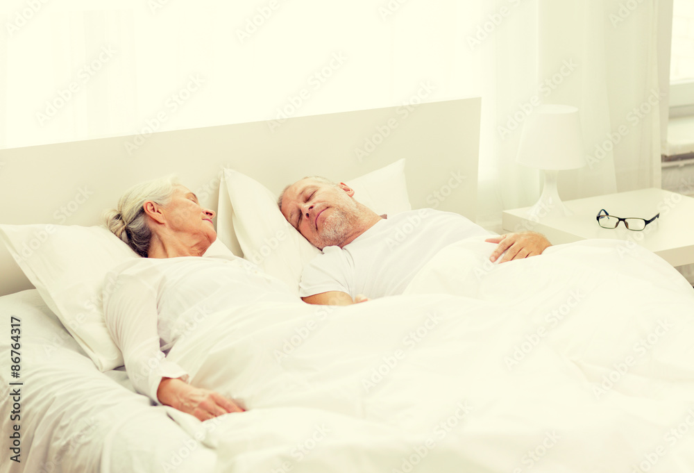 happy senior coupler lying in bad at home happy senior coupler lying in bad at home