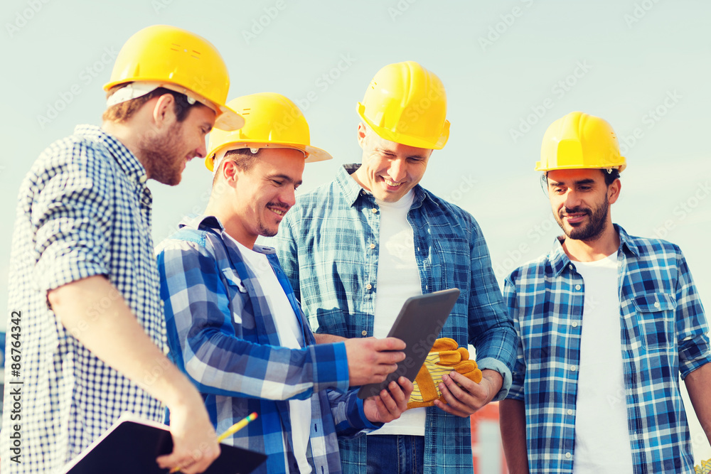 group of smiling builders with tablet pc outdoors group of smiling builders with tablet pc outdoors