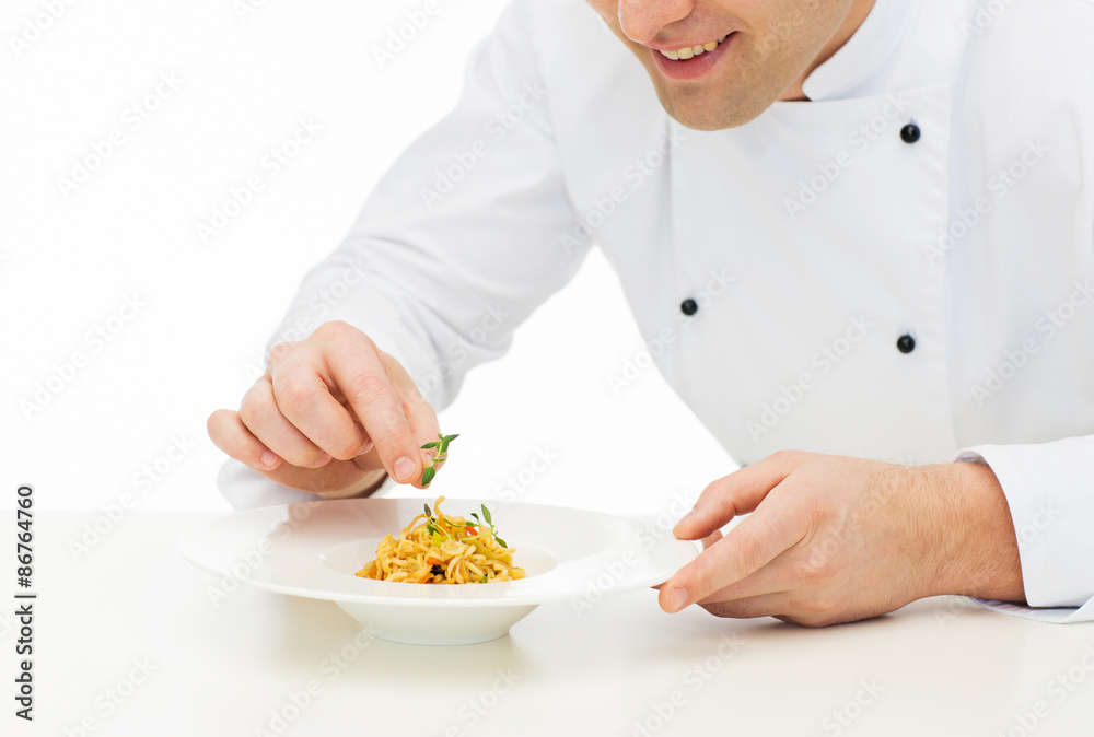 close up of happy male chef cook decorating dish close up of happy male chef cook decorating dish