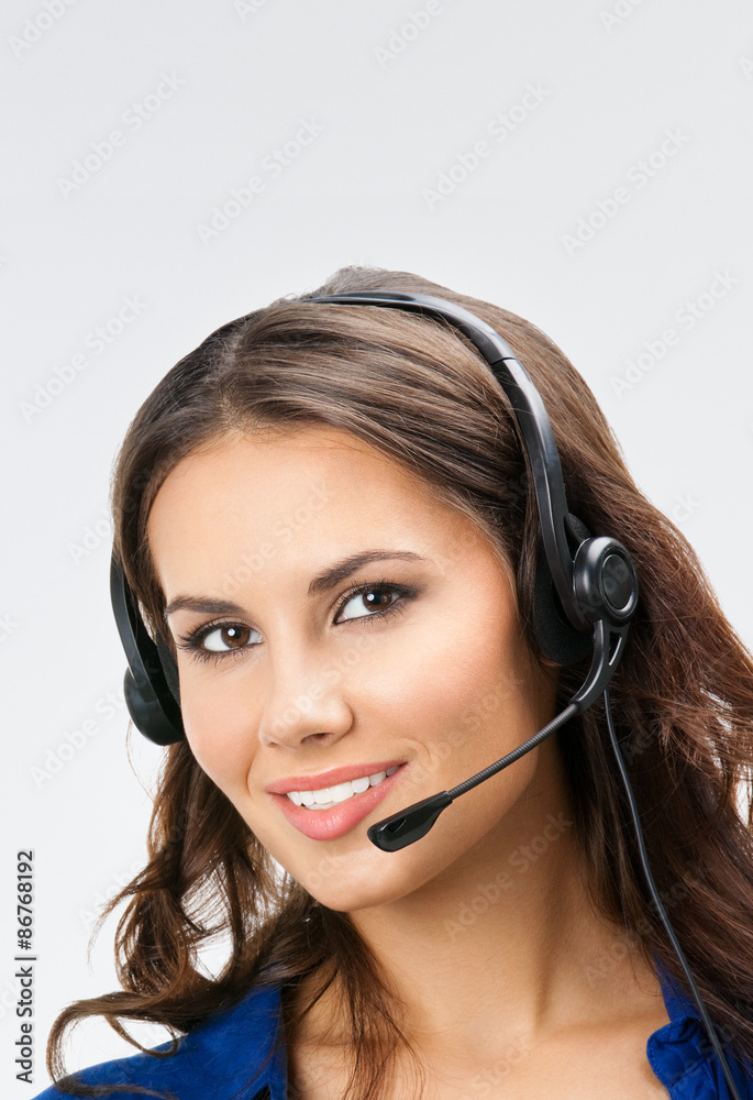 smiling young support phone operator, with copyspace, on grey smiling young support phone operator, with copyspace, on grey