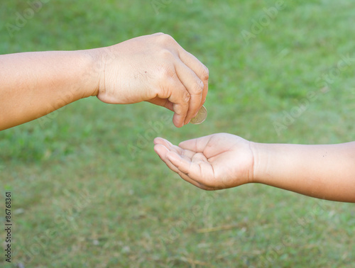 Hand gives coin to a boy © kittikorn Ph.