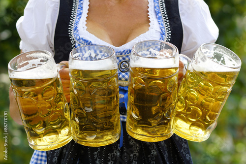 Bedienung im Biergarten mit vier Mass Bier