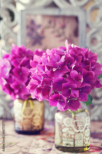 beautiful purple hydrangea flowers in a vase on a table . 