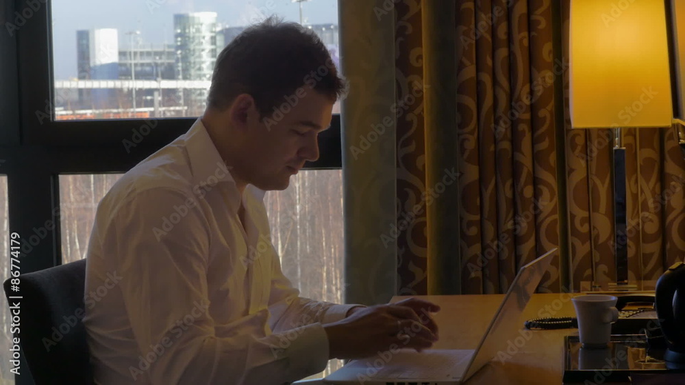 Young businessman working with laptop and receiving call Young businessman working with laptop and receiving call