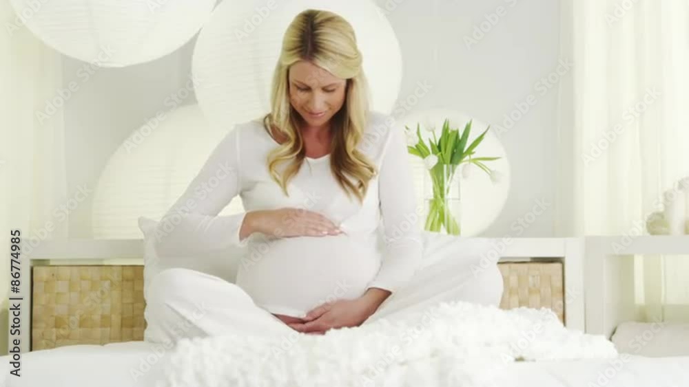 Beautiful pregnant woman relaxing on bed Beautiful pregnant woman relaxing on bed