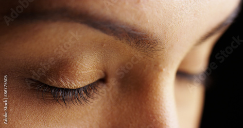 Close up of woman with closed eyes on black background photo