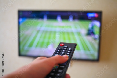 Hand with the remote control, front of the television.